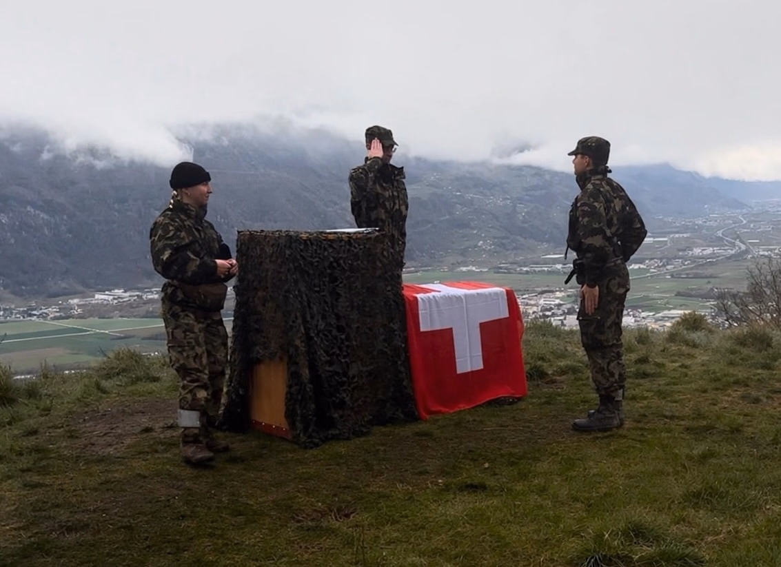Soldatierung von Timo Maibach vor einer Schweizer Flagge